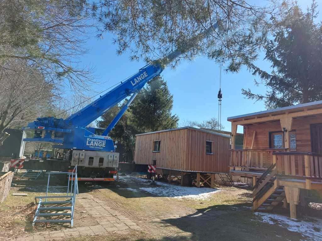 Kran hebt Container auf Gestell.