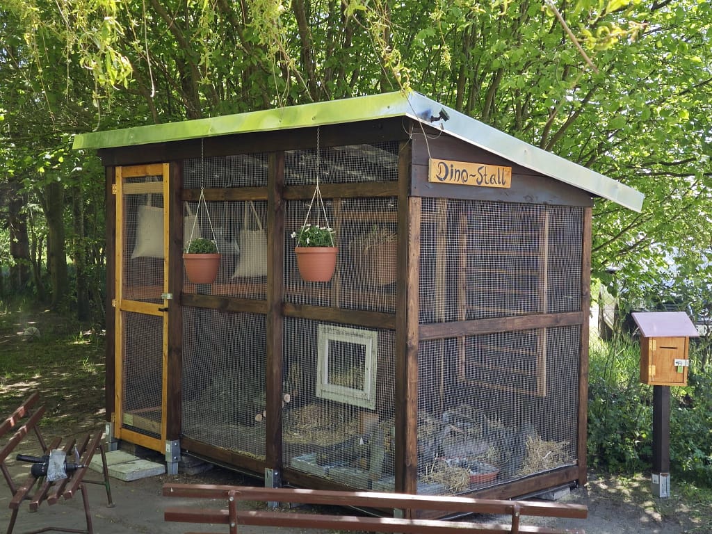 Kleintiergehege mit Hasen unter einem Baum