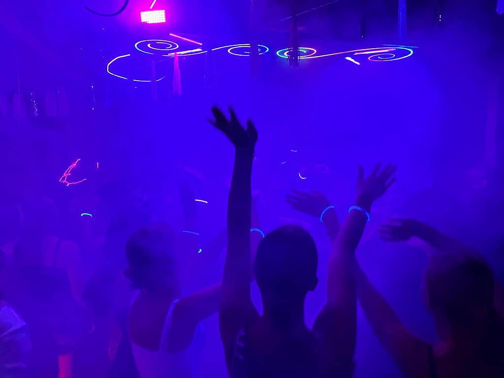 Diskoschuppen mit blauer Beleuchtung und tanzenden Menschen.